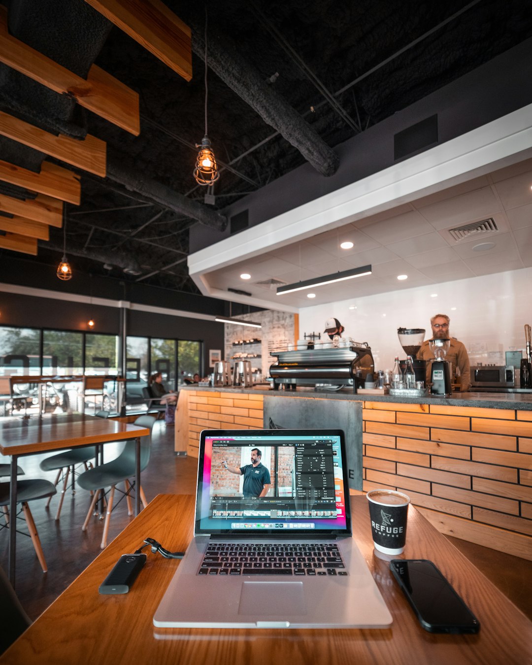 A Macbook Pro with a Final Cut Pro open in a coffee shop.